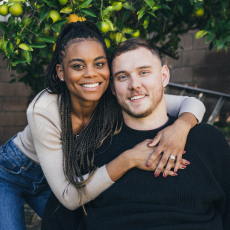 Cole & Charisma smiling and embracing in front of a lemon tree.
