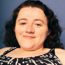 Kristen Lopez smiling wearing a black and white patterned top.