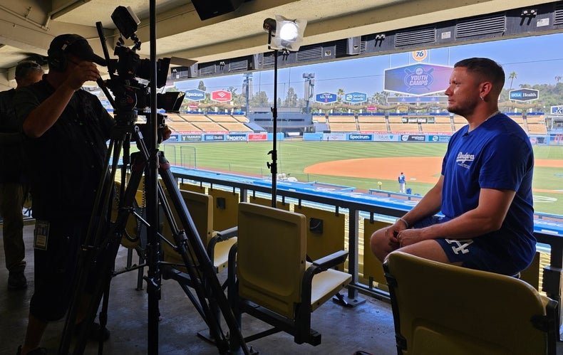 Miguel Rojas sitting the in stands at a baseball stadium.