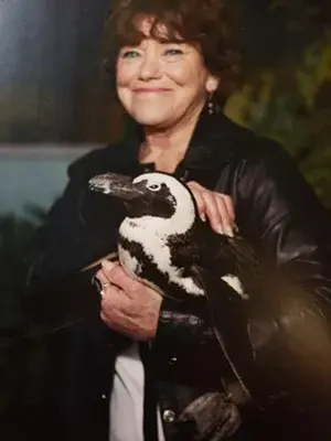 linda holding a penguins smiling