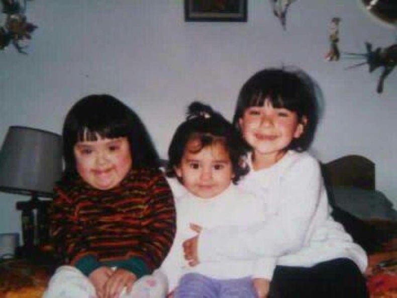 Three children sitting on a bed at their grandparents house. 