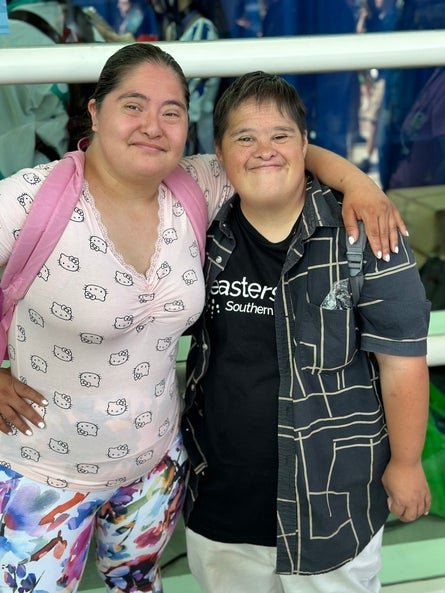 Two individuals smiling and posing for a photo, one wearing a Hello Kitty t-shirt and the other in a Easterseals t-shirt.