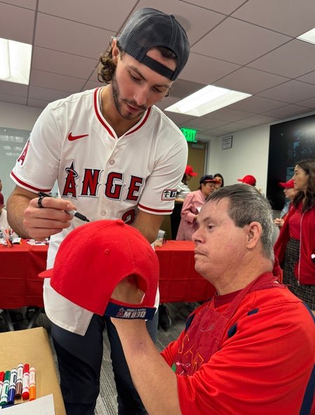Bryce signing an Angels baseball hat. 