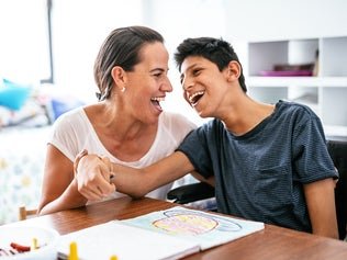 two people smiling while sitting at a table