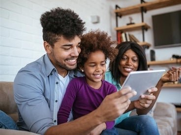 male holding tablet while child and woman look at tablet