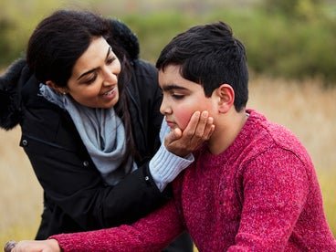 women holding face of young boy