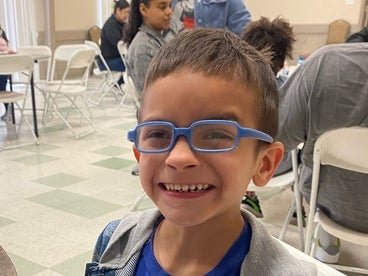 dominic smiling at a table eating pancakes