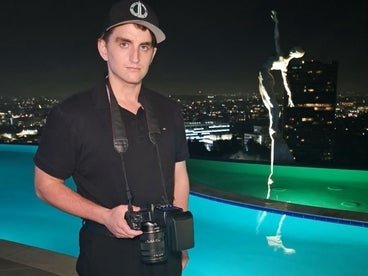 connor with his camera next to a pool at night in the city