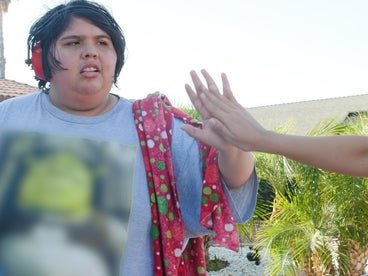 A photo of Ady high-fiving her family member and wearing noise cancelling headphones.