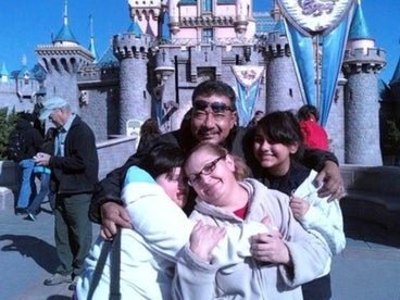 Monica and her family in front of the Disneyland castle. 