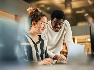a man and a woman looking at a laptop
