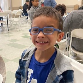dominic smiling at a table eating pancakes