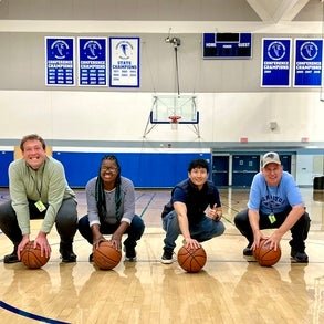 Individuals from Easterseals Adult Day Services holding basketballs in a gym