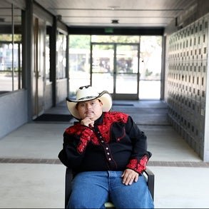 jose sitting down with his hand on his chin wearing a cowboy hat