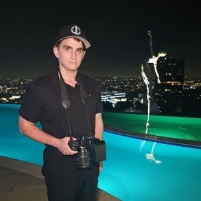 connor with his camera next to a pool at night in the city