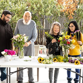 linda and other participants putting flowers in a vase