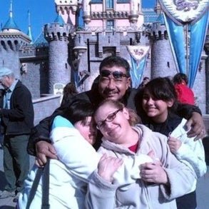 Monica and her family in front of the Disneyland castle. 