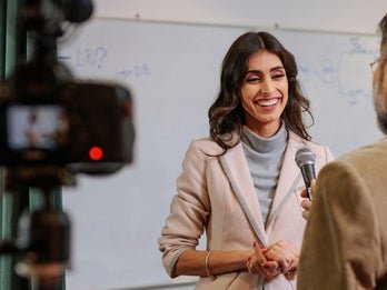 A banner image of a woman being interviewed on camera.