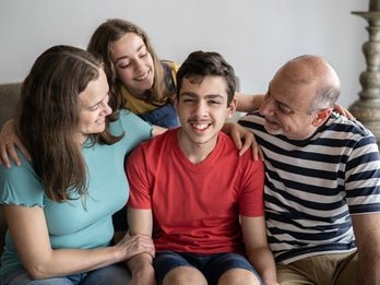 young boy with disability surrounded by family
