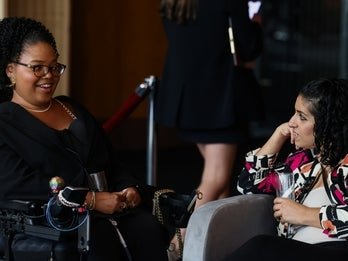 Two individuals in a conversation during an event. 