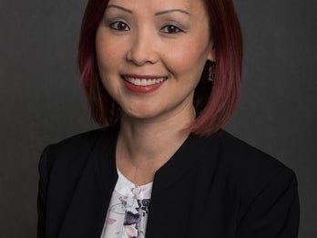 Dr. Joyce Tu headshot wearing a black blazer with redish brown hair