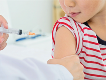 A doctor administering a shot to a young boy in a medical office. 