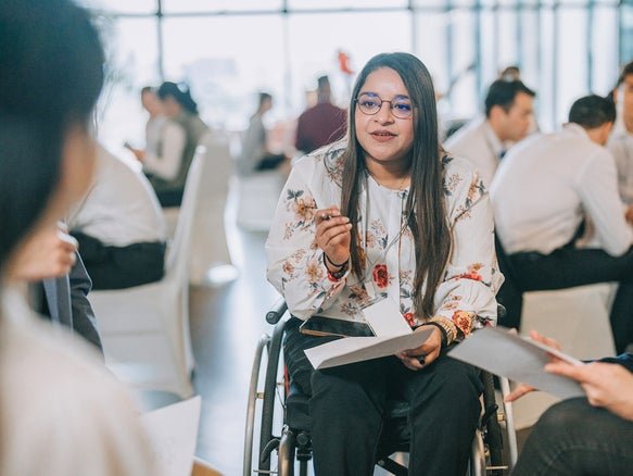 a young woman sitting in her wheelchair having a conversation