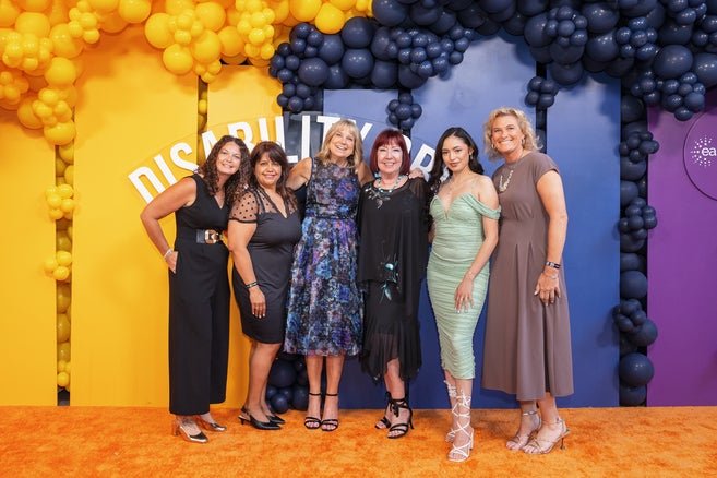 6 members of the Easterseals team posing in front of a colorful backdrop 