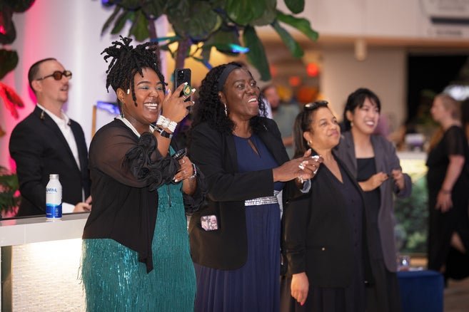 Several guests smiling, clapping and enjoying the live music