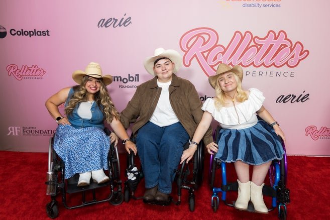 Three people using wheelchairs and dressed in western gear in front of the Rollettes step and repeat 