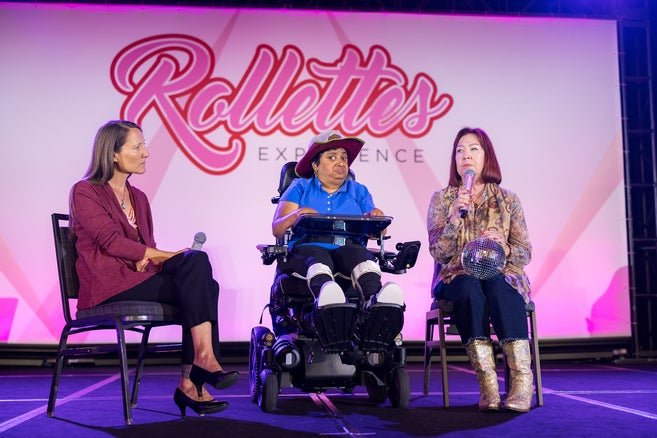 Easterseals participant Preeti (center) on stage with Kathleen Kolenda (right)