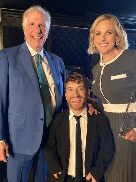 Henry Winkler, Nic Novicki, and Marlee Matlin inside in auditorium.
