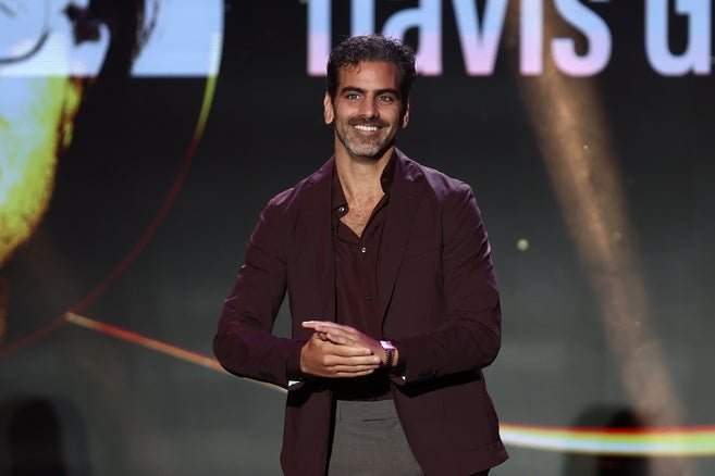 Nyle DiMarco on stage speaking at an award ceremony. 