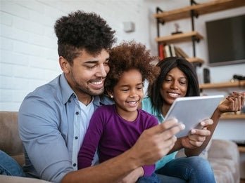 male holding tablet while child and woman look at tablet