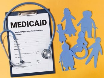 clipboard with medicaid chart and blue paper cutouts of people with disabilities