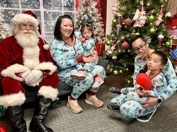 A pair of parents and their kids with Santa. 
