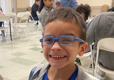 dominic smiling at a table eating pancakes